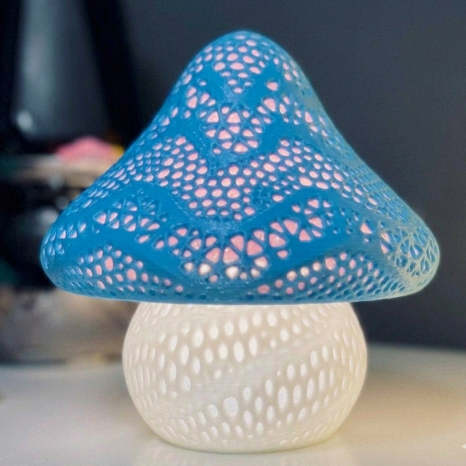 Mushroom-shaped lamp with blue perforated top and white base on a blurred background