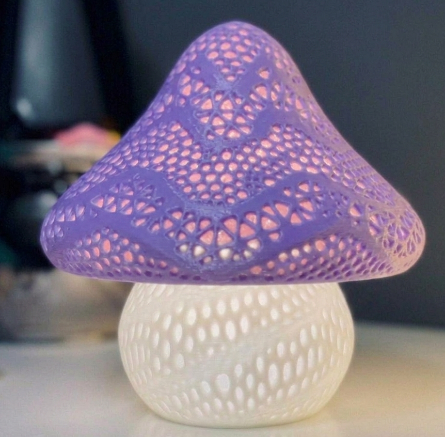 Mushroom-shaped lamp with purple top and white base on a blurred background