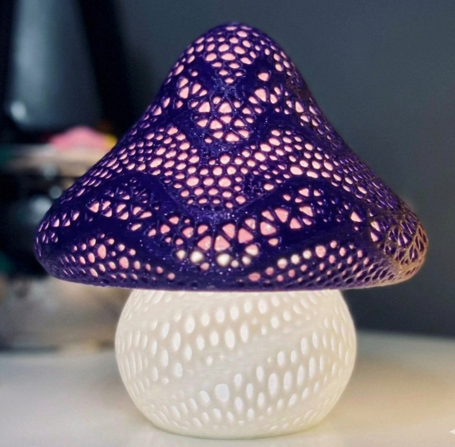 Mushroom-shaped lamp with purple top and white base on a blurred background